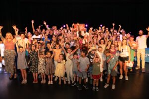 A group photo of all Framework's Young Supporters and staff holding up glow sticks