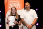 Adam and Lewis standing with his certificate at the YSA 2026. They are both smiling and standing in front of a Young Supporter Awards banner.